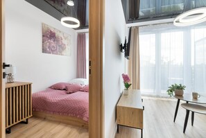 Escritorio, tabla de planchar con plancha, wifi y ropa de cama