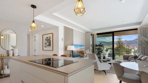 Een moderne keuken met een centraal eiland, een eethoek met een ronde tafel en een zithoek.