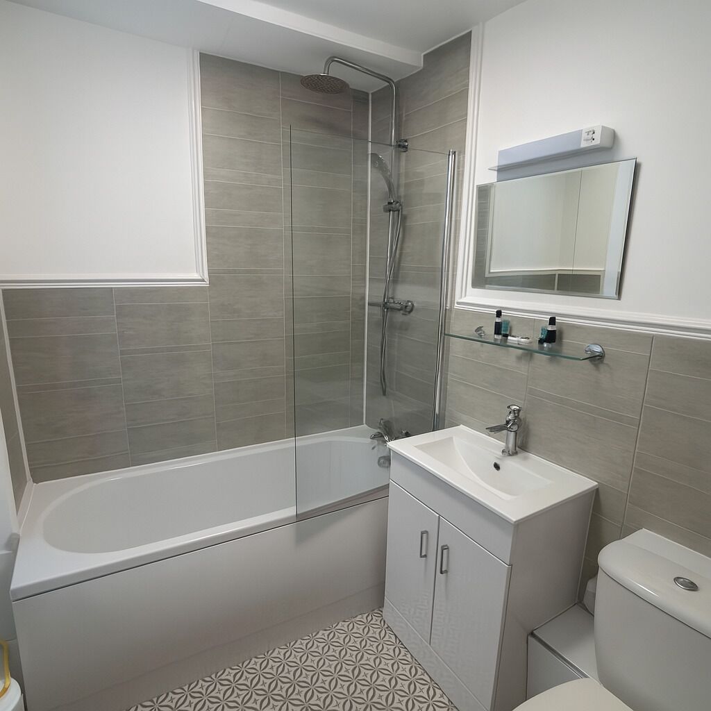 Un baño moderno con bañera, ducha e inodoro.