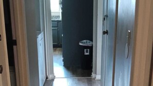Un pasillo con piso de madera que conduce a una zona de cocina.
