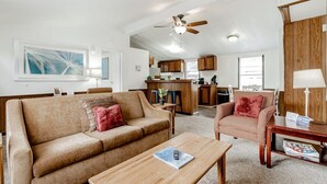 A spacious living area with a sofa, armchair, and coffee table. A kitchen is visible in the background with wooden cabinets and a dining area. - 15mins to Downtown- Adorable on Taylor, Both Units (West Columbia)