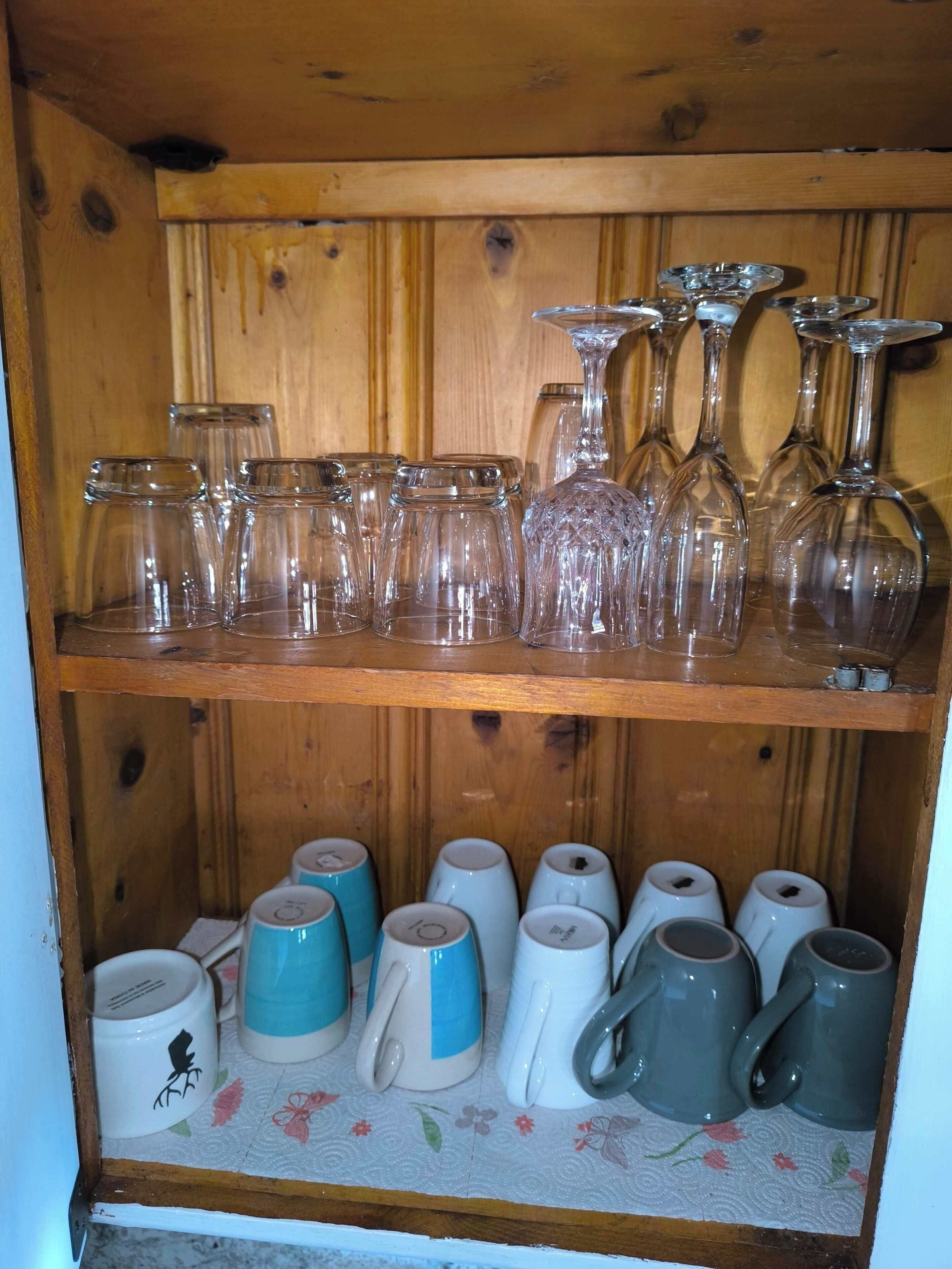 Una estantería de madera con diferentes vasos y tazas.