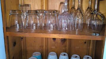 Una estantería de madera con diferentes vasos y tazas.