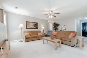 Relax in this stylish living room with a large sofa, coffee table, and floor lamp.