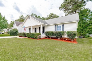 Situated in a quiet suburban neighborhood, this charming home features a gabled roof and a welcoming front porch.
