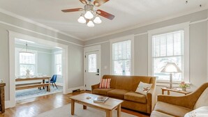 A spacious living room with a wooden coffee table, a brown sofa, and a ceiling fan.