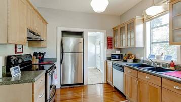 A kitchen with wooden cabinets, stainless steel appliances, a microwave, and a sink.