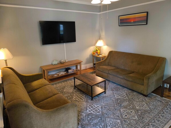 Relax in style with a flat-screen TV, comfortable sofa, and cozy armchair.