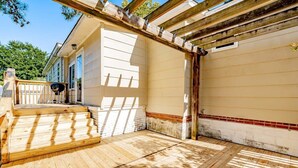 A wooden deck with steps leading to a house.