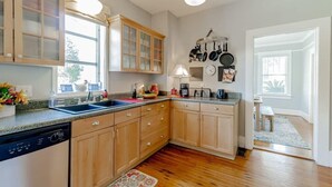 A kitchen with wooden cabinets, a dishwasher, and a window.