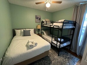 Cozy retreat with a single bed, bedside table, and ceiling fan.