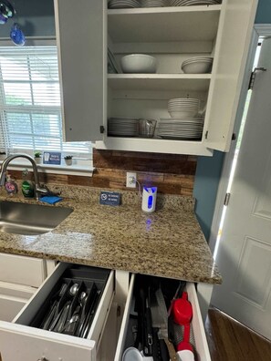 Kitchen area with sink, modern faucet, and stainless steel range hood.