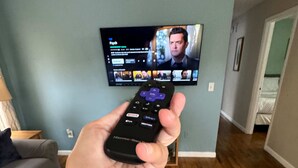 A hand holding a remote control in front of a television displaying a streaming service interface. - Close to USC & Midtown-Downtown - Newly Renovated! (Columbia)