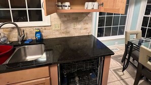Una cocina con lavavajillas, un lavabo y una ventana sobre la encimera.