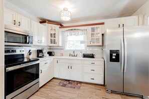 Enjoy cooking in this well-equipped kitchen with a microwave, oven, and refrigerator.