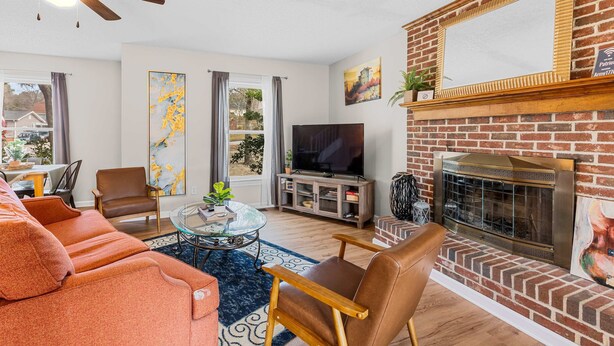 A living room with a fireplace, a television, and a dining area with a table and chairs. - Large Private Yard, Near USC! - The Garnet Goliath (Columbia)