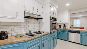 A modern kitchen with white cabinets, a blue countertop, and a dishwasher. - Mins to Lake Murray & Downtown - The Settle-Inn (Irmo)