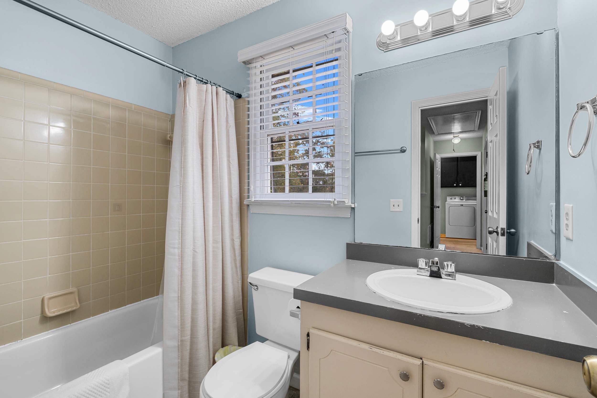 A bathroom with a bathtub, toilet, and sink.