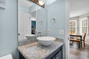 A bathroom with a white sink, granite countertop, and a large mirror. - Near Bases & USC - Stay At The Gamecock Cutie! (Columbia)