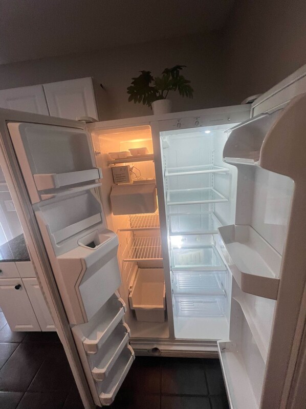 An open refrigerator with multiple shelves and a freezer compartment.