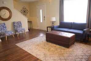 Cozy living space with a sofa, armchairs, and ottoman.