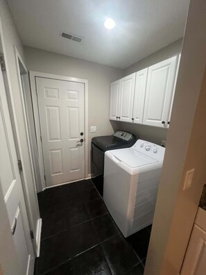 Convenient laundry facilities feature a washing machine and storage above.