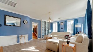 A spacious living room with a large sofa, a coffee table, and a bookshelf. - Near Downtown & On the Water! Sweet Retreat! (Columbia)