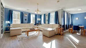 A spacious living room with a large sofa set, a coffee table, and a dining area with wooden furniture. - Near Downtown & On the Water! Sweet Retreat! (Columbia)
