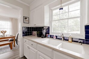 Kitchen features a large window, stainless steel sink, and ample countertop space.
