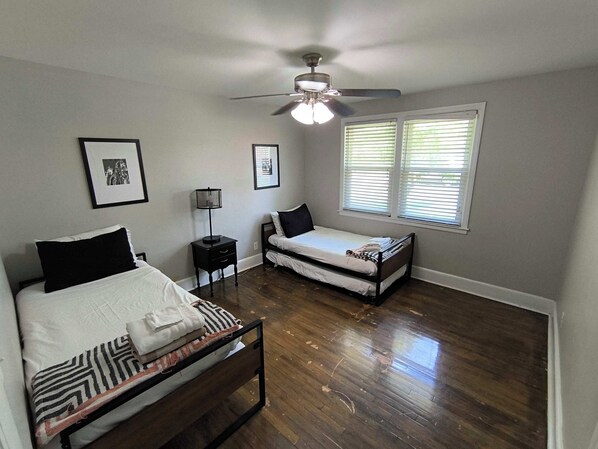 Cozy retreat with a single bed, nightstand, and ceiling fan.
