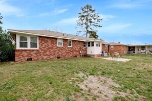 Stroll through the charming front yard, featuring a large tree and a single-story home with a garage and front entrance.