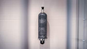A Baylis & Hardeng Elements white tea and neroli body wash dispenser mounted on a wall.