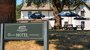 Ein Schild für ein Hotel mit einem Pfeil, der nach links zeigt und den Standort des Hotels anzeigt.
