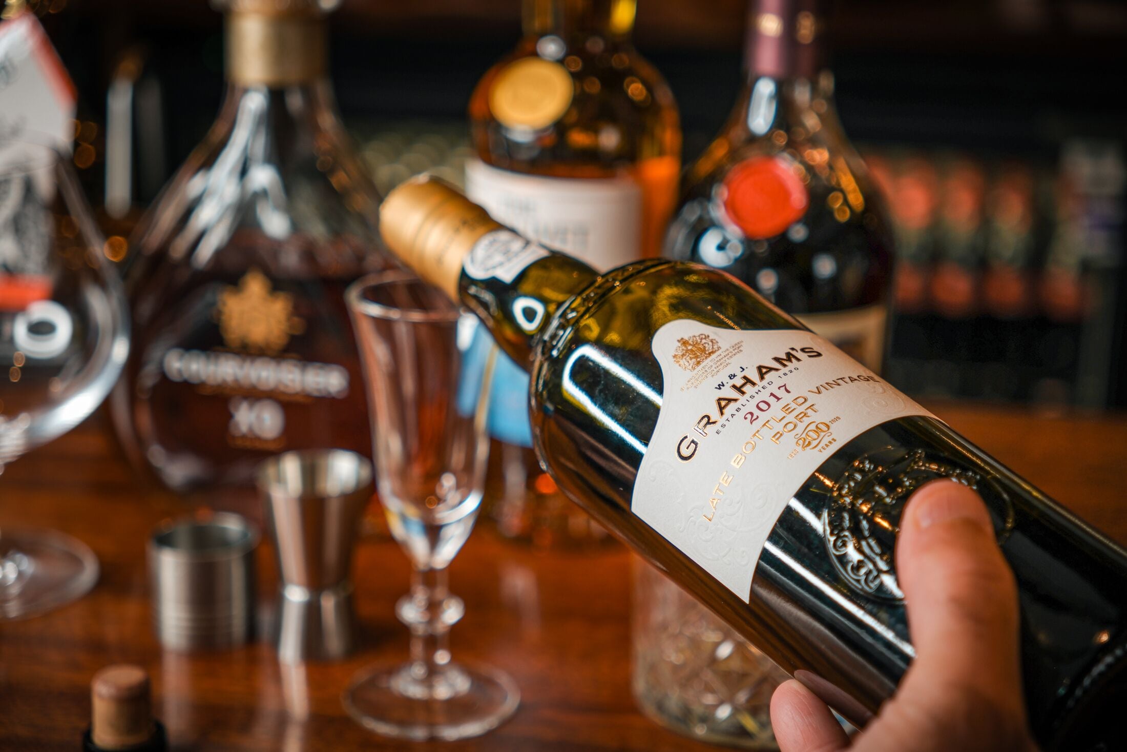 A hand holding a bottle of Graham's 2017 Late Harvest Port.