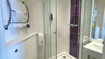 A modern bathroom with a glass-enclosed shower, a white toilet, and a sink.