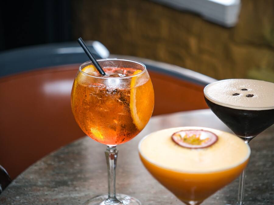 Dos copas sobre una mesa, una de martini y otra de cóctel.