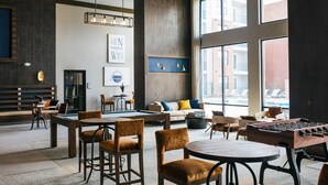 A spacious indoor area with a pool table, seating arrangements, and large windows offering views of the outside. - Landing | Chic 1BD, Clubhouse, Gym (Knoxville)