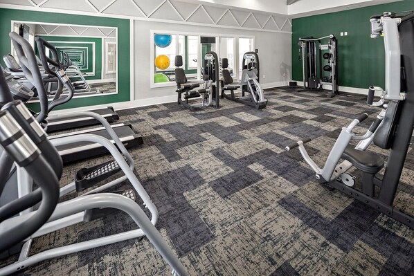 A gym with treadmills, elliptical machines, and weight equipment.