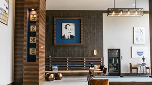 A modern lobby with a pool table, seating area, and framed artwork on the walls.