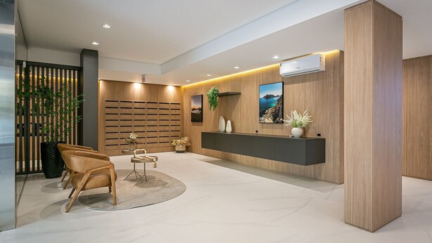 A modern reception area with a wooden reception desk, a seating area with chairs, and a large potted plant. - Gastronomy | Hot Tub | Gym #TRINA04 (Florianópolis)
