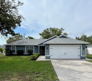 Stunning home with a garage, front entrance, and beautifully manicured lawn.