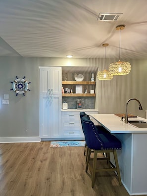 Enjoy cooking in this well-equipped kitchen with a central island, sink, and bar stools.