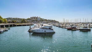 A marina with multiple boats docked, a bridge, and buildings in the background. - Harcombe House Rooms - First Floor Single (Newton Abbot)