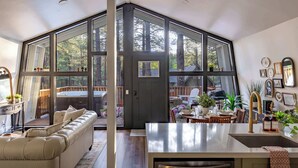 Eine moderne Küche mit einer großen Kücheninsel, einem Essbereich mit Tisch und Stühlen sowie einer gemütlichen Sitzecke mit einer Couch.