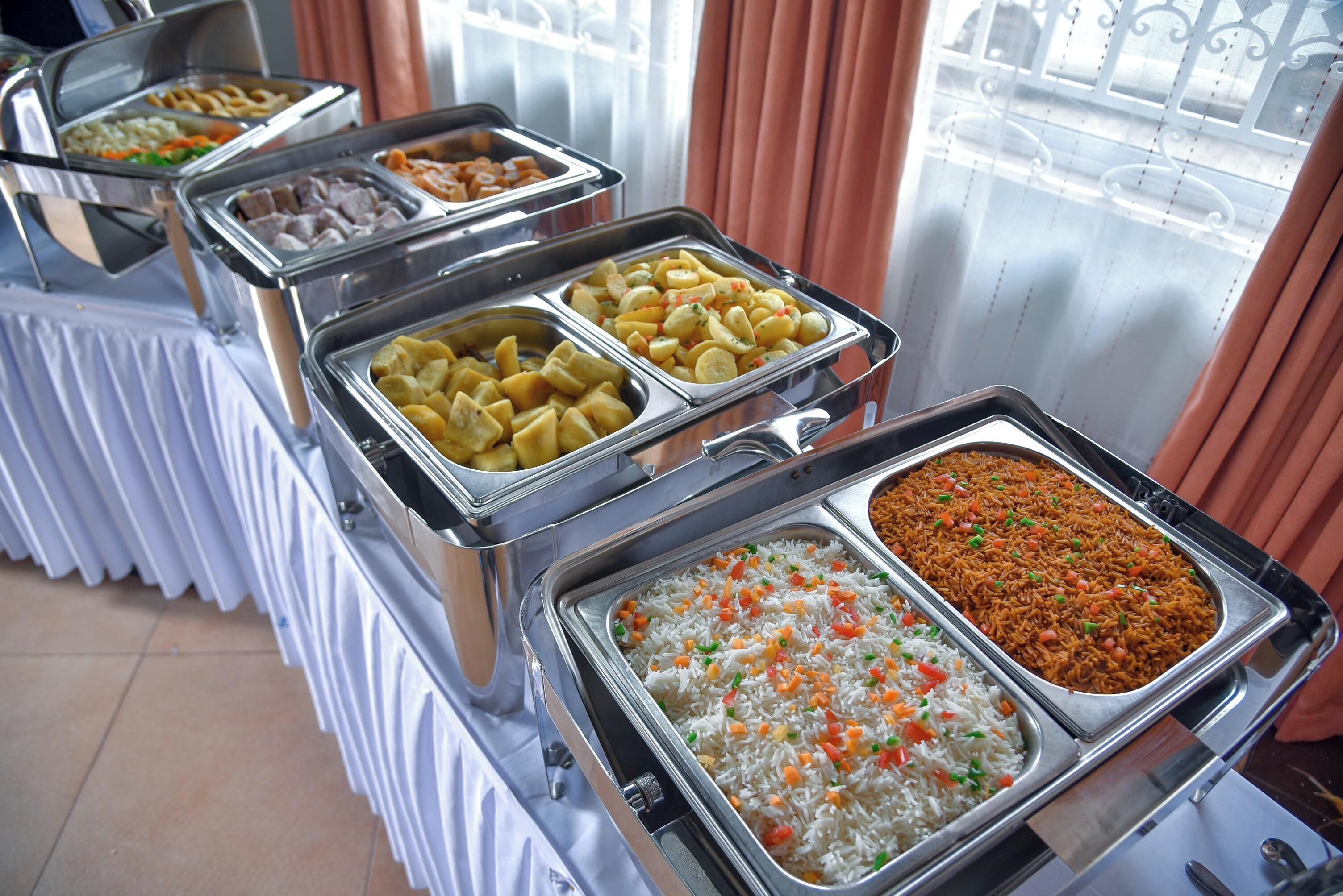 A buffet with various food options including rice, potatoes, and other dishes.