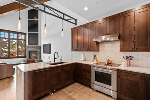 Una cocina moderna con armarios de madera, un horno de acero inoxidable y una isla grande con pileta.