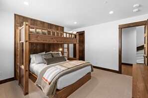 A bedroom with a bunk bed, a wooden headboard, and a carpeted floor. - *NEW TO MARKET* Mountain Chalet | 2 Min from Big Sky Resort | Hot Tub (Big Sky)