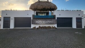 Een modern gebouw met rieten dak, twee grote garage deuren en een bordje met de tekst '30NVANT'.