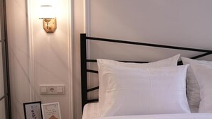 A neatly made bed with white linens and a black metal headboard in a hotel room.