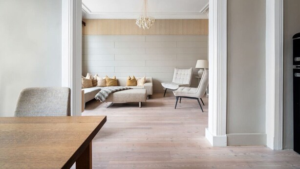 A modern living room with a sofa, armchairs, and a dining table. - Experience the luxury lifestyle 100m from Bryggen! (Bergenhus)